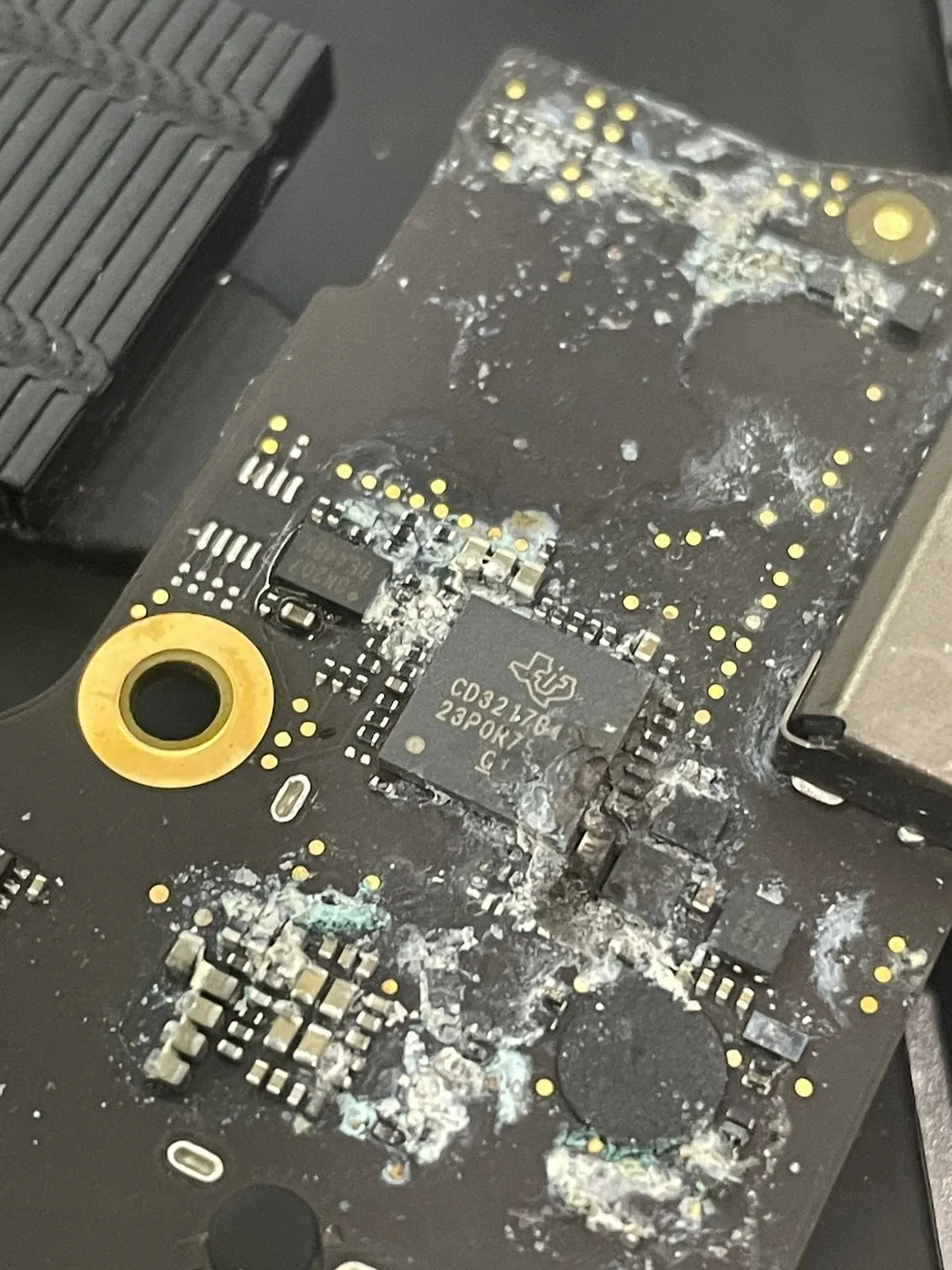 Daño por líquido y corrosión en una placa lógica de MacBook