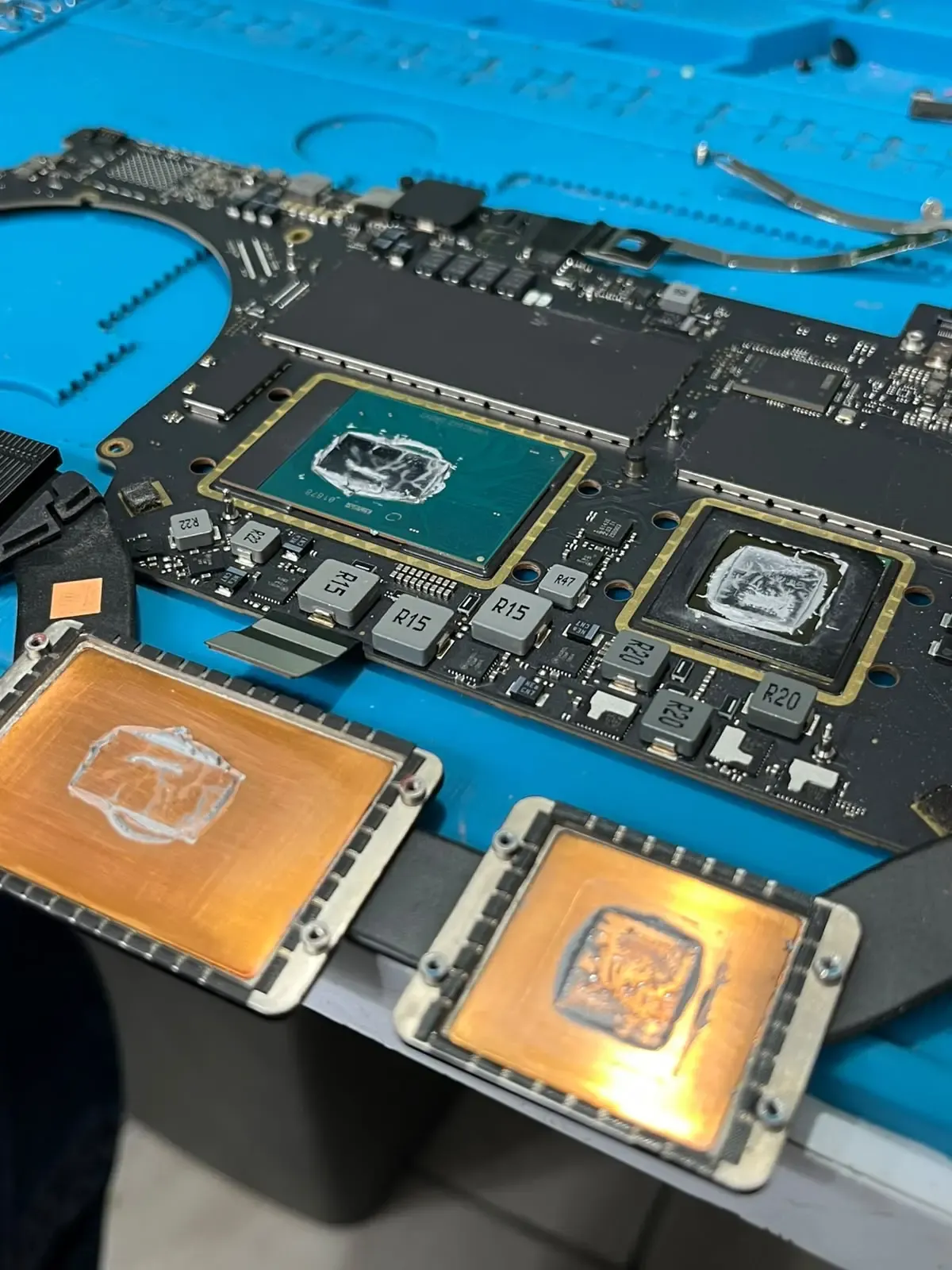 Tarjeta lógica de MacBook Pro con CPU y GPU destapados durante el cambio de pasta térmica